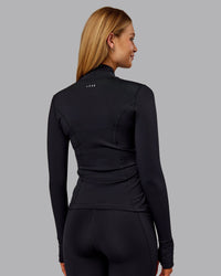 Woman wearing Stride Thermal Zip Through Jacket - Black | Model:Ella | Size:S