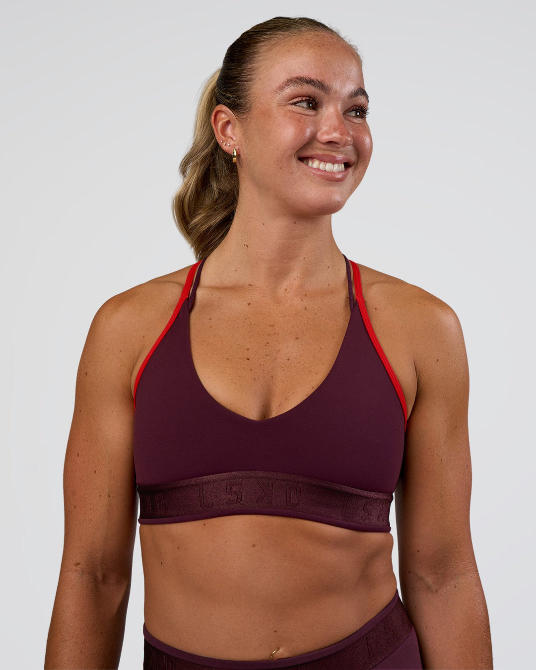 Woman wearing Strive Jacquard Sports Bra - Cherry Lacquer | Model:Sav | Size:S