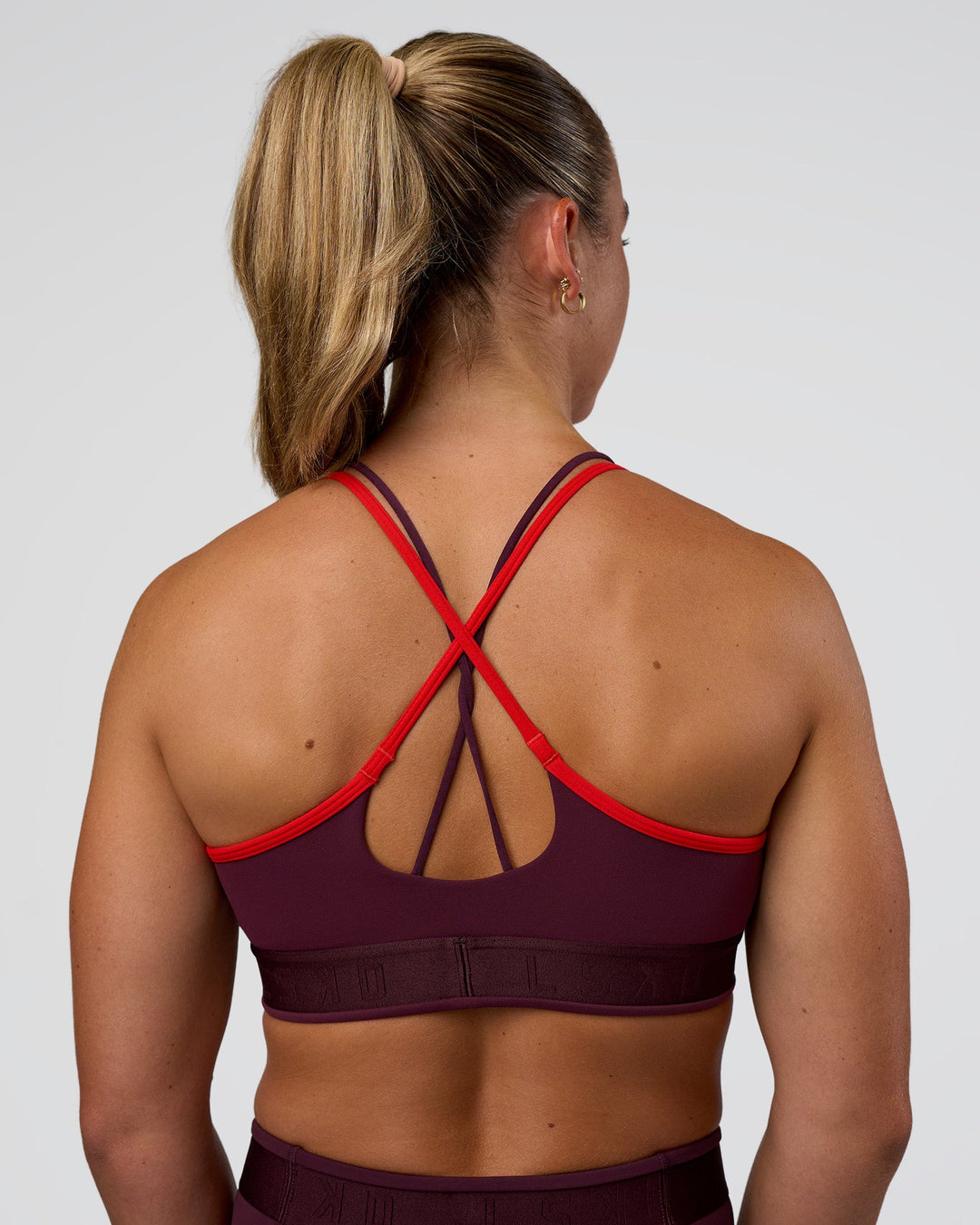Woman wearing Strive Jacquard Sports Bra - Cherry Lacquer | Model:Sav | Size:S