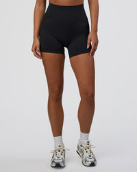 Woman wearing Surge Seamless High-Rise 4" Short - Black | Model:Bianca | Size:S