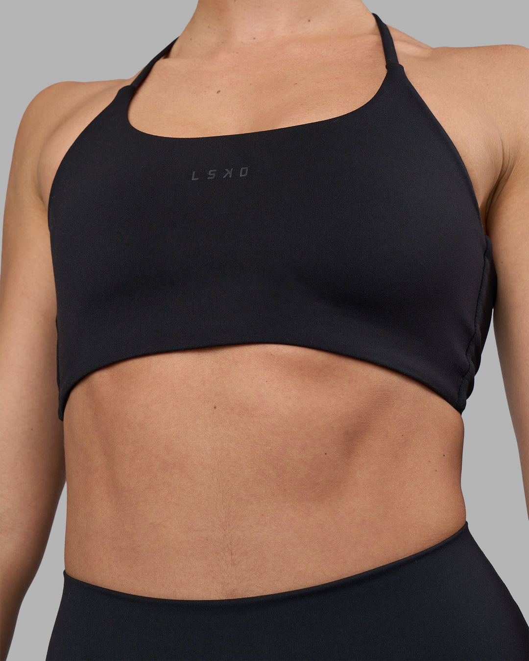 Woman wearing Twist Sports Bra - Black | Model:Sophie | Size:S