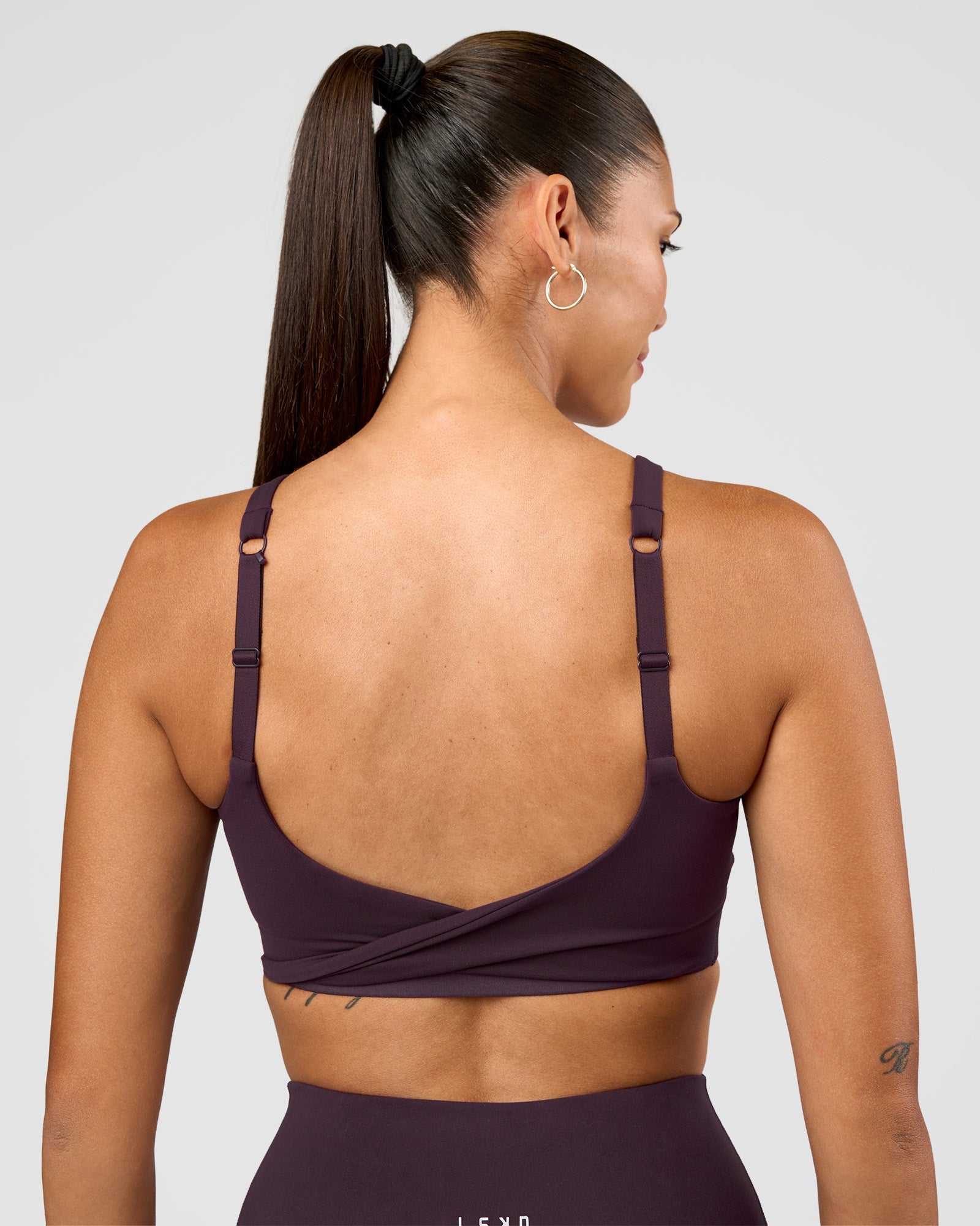 Woman wearing Twist Sports Bra D/DD/E - Midnight Plum | Model:Rhiley | Size:S
