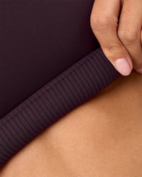 Woman wearing Twist Sports Bra D/DD/E - Midnight Plum | Model:Rhiley | Size:S