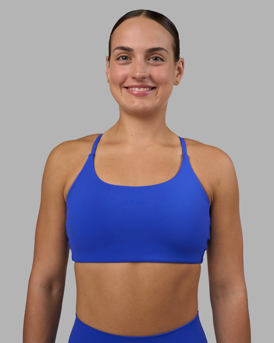 Woman wearing Twist Sports Bra - Power Cobalt | Model:Keisha | Size:S