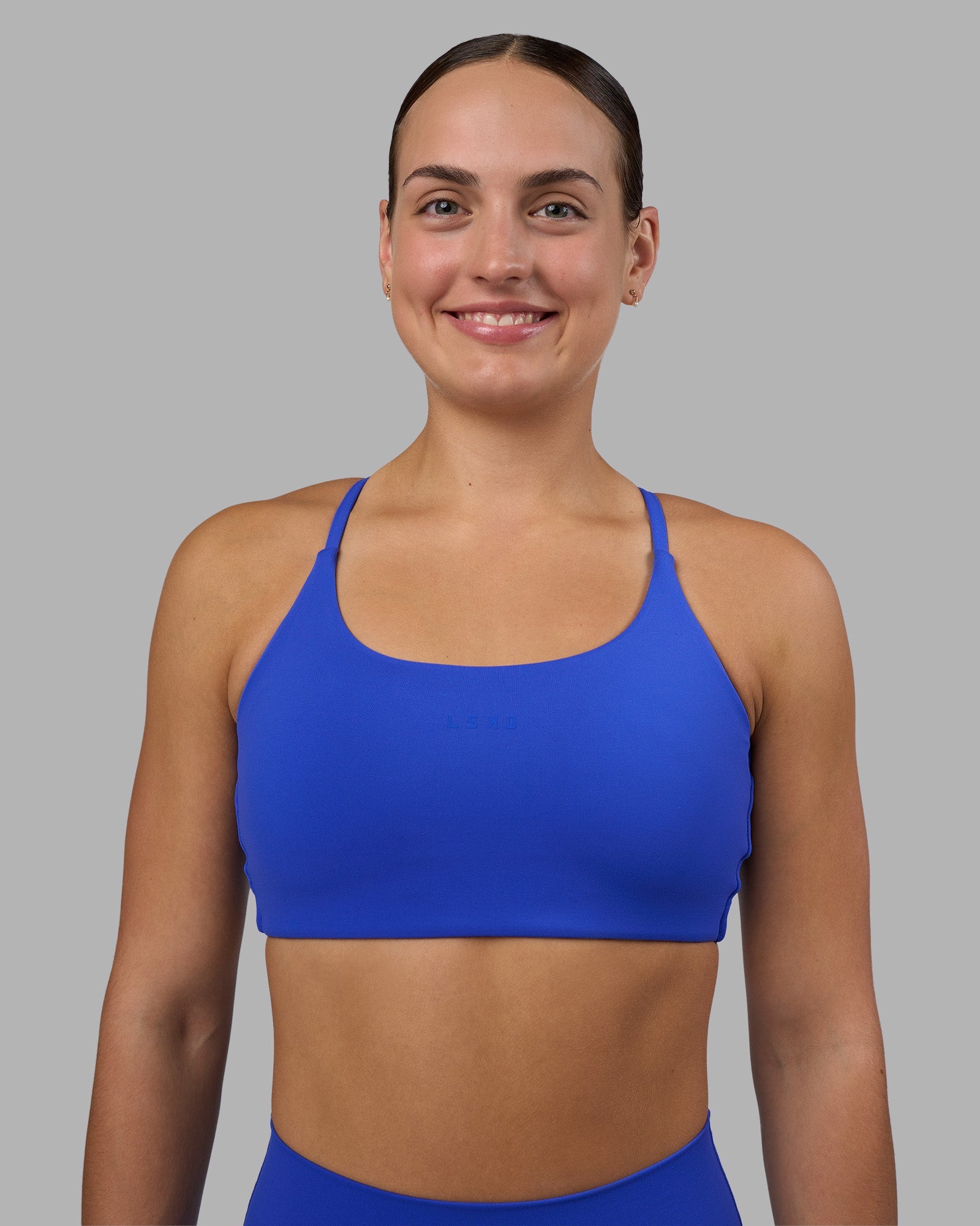 Woman wearing Twist Sports Bra - Power Cobalt | Model:Keisha | Size:S