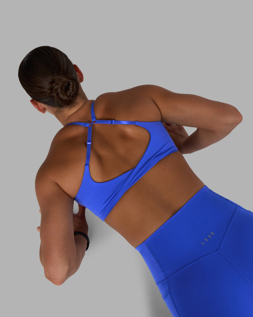 Woman wearing Twist Sports Bra - Power Cobalt | Model:Keisha | Size:S
