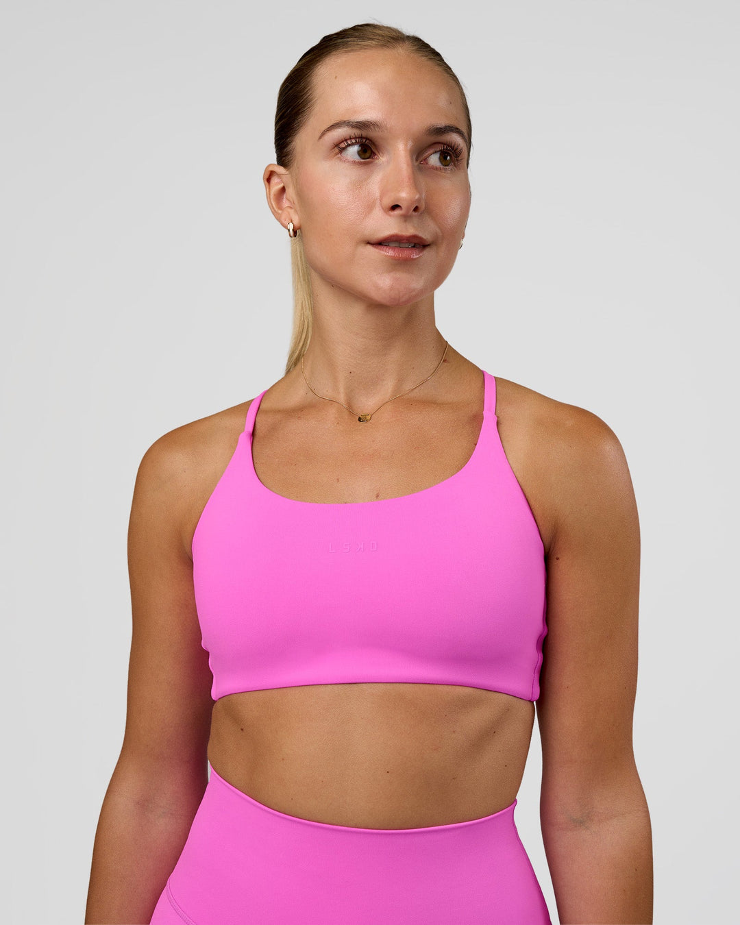 Woman wearing Twist Sports Bra - Ultra Fuchsia | Model:Myrte | Size:S - view 1