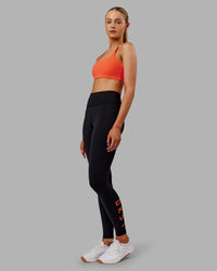 Woman wearing Twist Sports Bra - Ultra Orange | Model:Ella | Size:S
