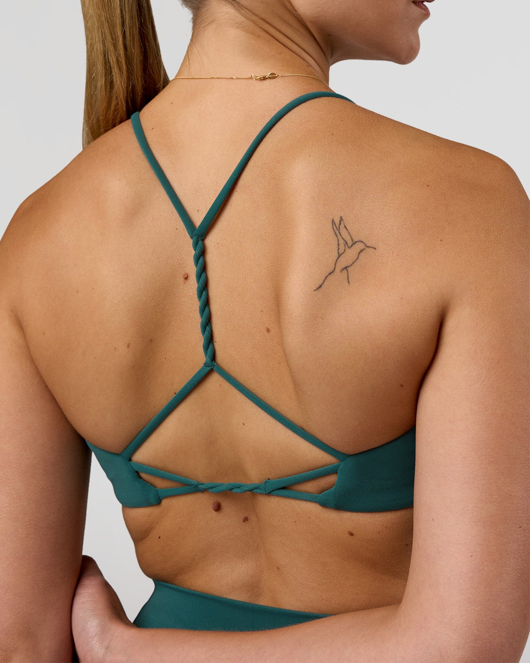 Woman wearing Twister Sports Bra - Transformative Teal | Model:Myrte | Size:S