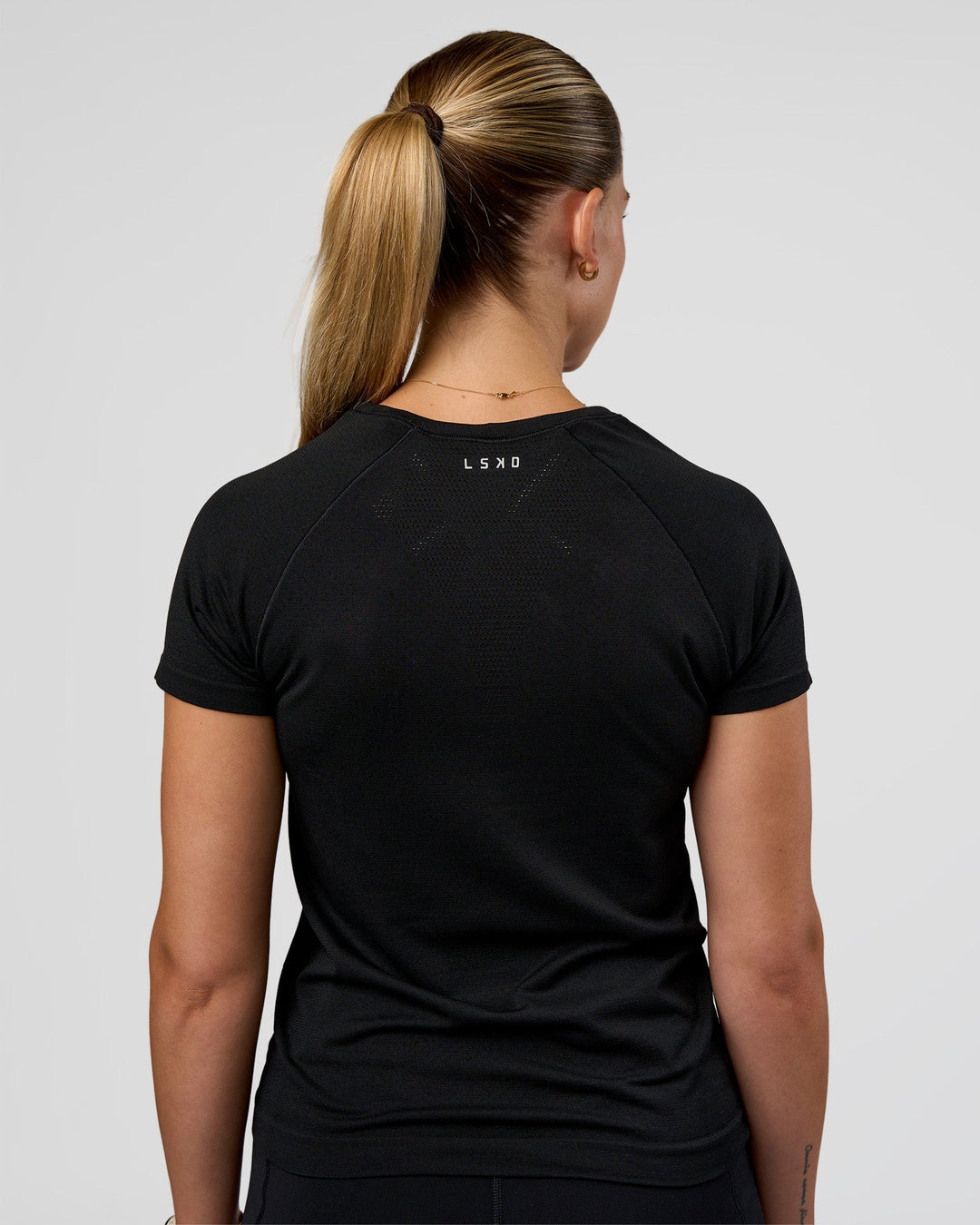 Woman wearing AeroFLX+ Seamless Tee - Black/Black | Model:Myrte | Size:S