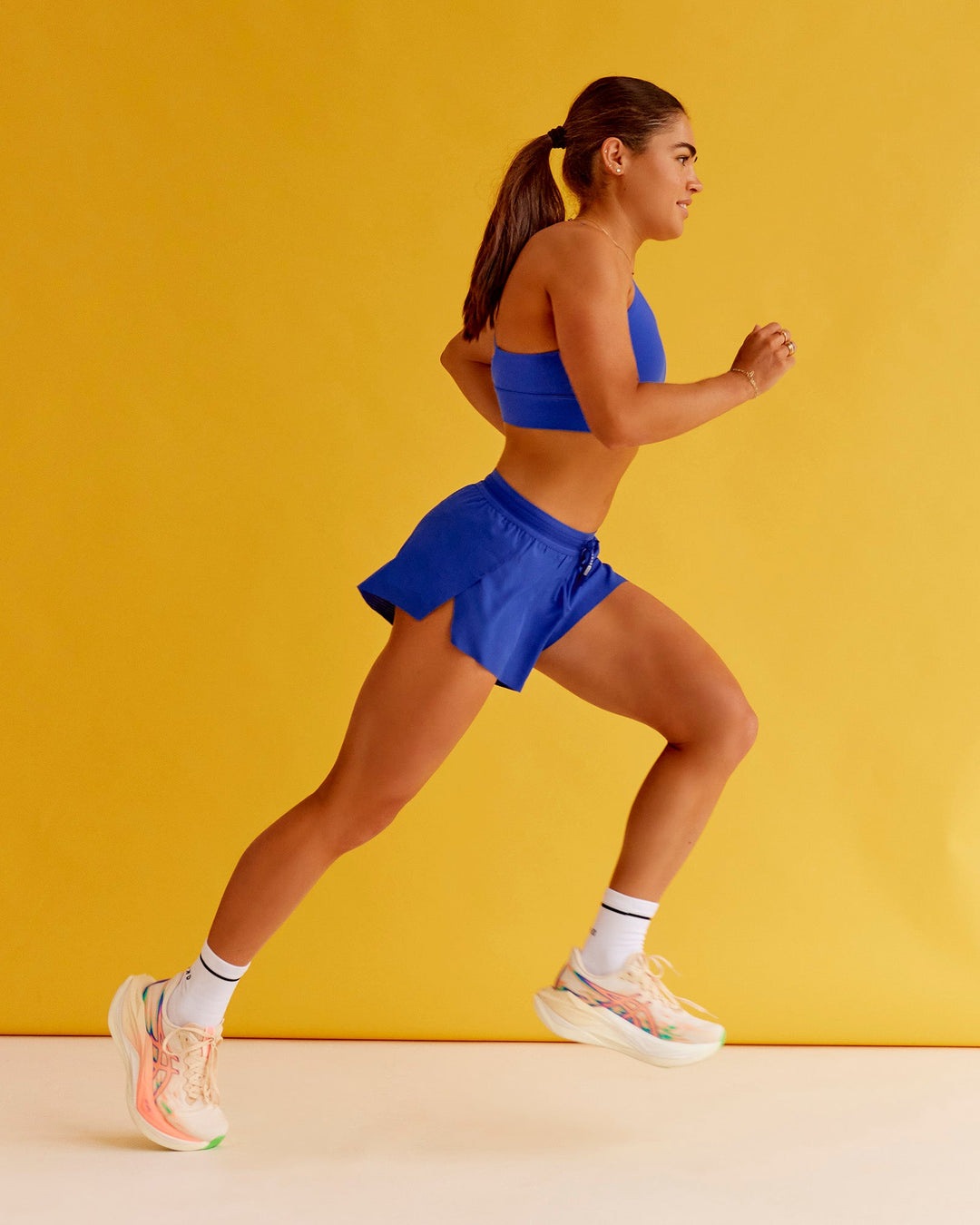 Woman wearing Accelerate 3" Mid-Rise Running Short - Electric Indigo | Set:true | Angle:closeup | Model:Bella | Size:XS