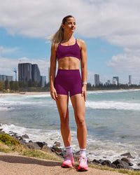 Woman wearing Elixir Defined High-Rise 4" Short - Plum Caspia | Model:Chloe | Size:XS