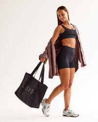 Woman wearing Surge Seamless High-Rise 4" Short - Black | Model:Brylee | Size:XS
