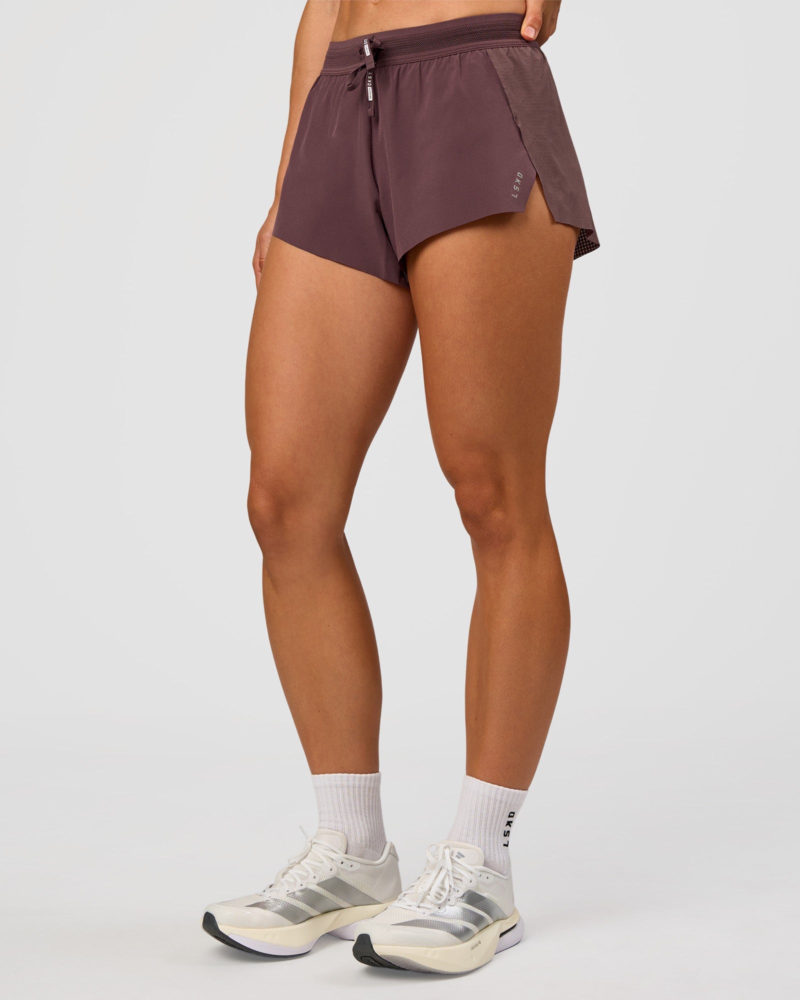 Woman wearing Accelerate 3" Mid-Rise Running Short - Cocoa Powder | Set:true | Angle:side | Model:Maja | Size:XS