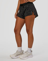 Woman wearing Accelerate 3" Mid-Rise Running Short - Energy Print Black | Set:true | Angle:side | Model:Brylee | Size:XS