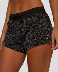 Woman wearing Accelerate 3" Mid-Rise Running Short - Energy Print Black | Set:true | Angle:closeup | Model:Brylee | Size:XS