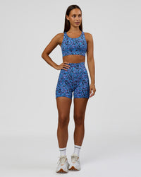 Woman wearing Accelerate Sports Bra in Energy Print Blue Multi | Model:Brylee | Size:XS