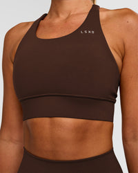 Woman wearing Accelerate Sports Bra - Hot Chocolate | Set:true | Angle:closeup | Model:Charli | Size:XS | Thumbnail Index: 0