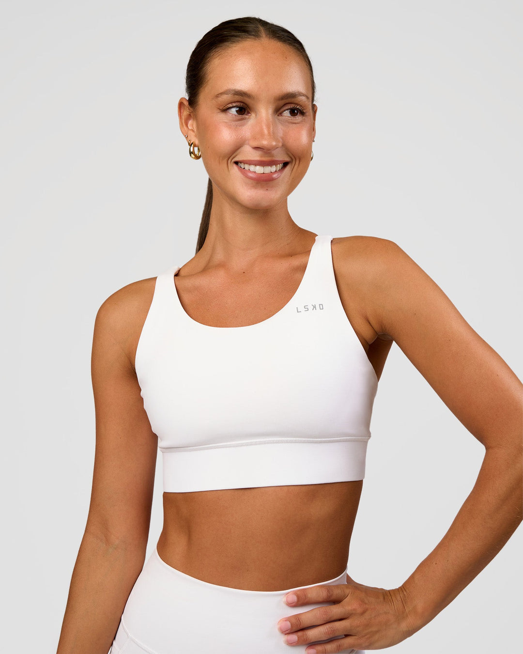 Woman wearing Accelerate Sports Bra - White | Set:true | Angle:front | Model:Brylee | Size:XS - view 1
