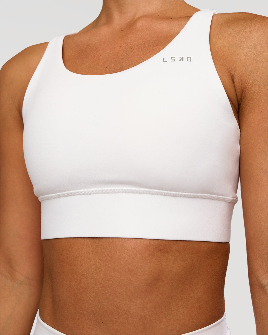 Woman wearing Accelerate Sports Bra - White | Set:true | Angle:closeup | Model:Brylee | Size:XS - view 4