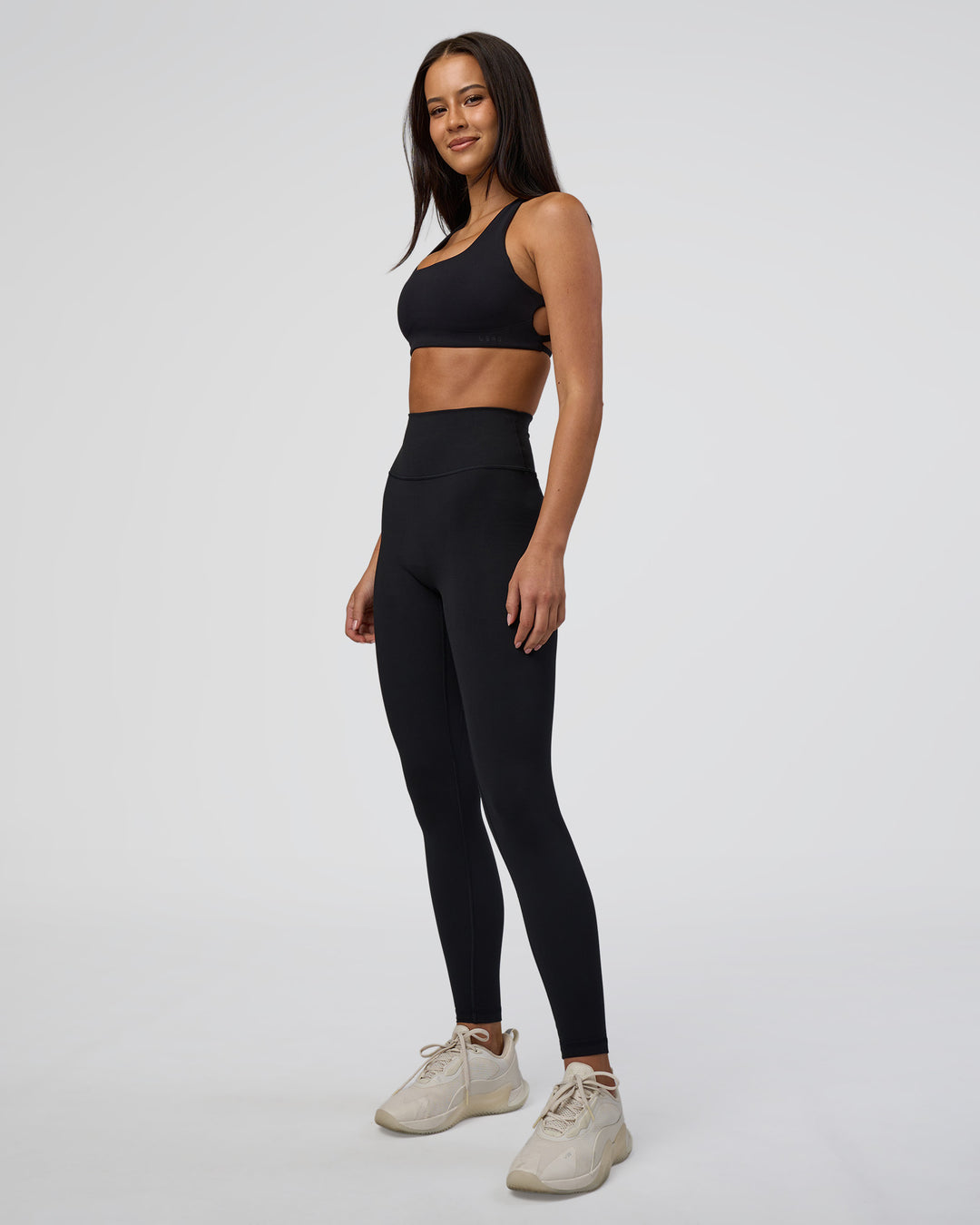 Woman wearing Aspire Sports Bra - Black | Model:Eliza | Size:XS