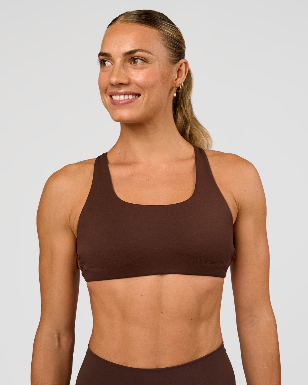 Woman wearing Aspire Sports Bra - Hot Chocolate | Model:Maja | Size:XS