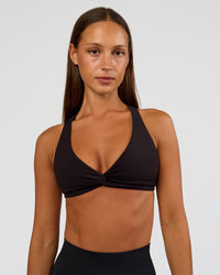 Woman wearing Aspire Twist Sports Bra - Black | Model:Brylee | Size:XS