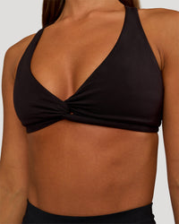 Woman wearing Aspire Twist Sports Bra - Black | Model:Brylee | Size:XS