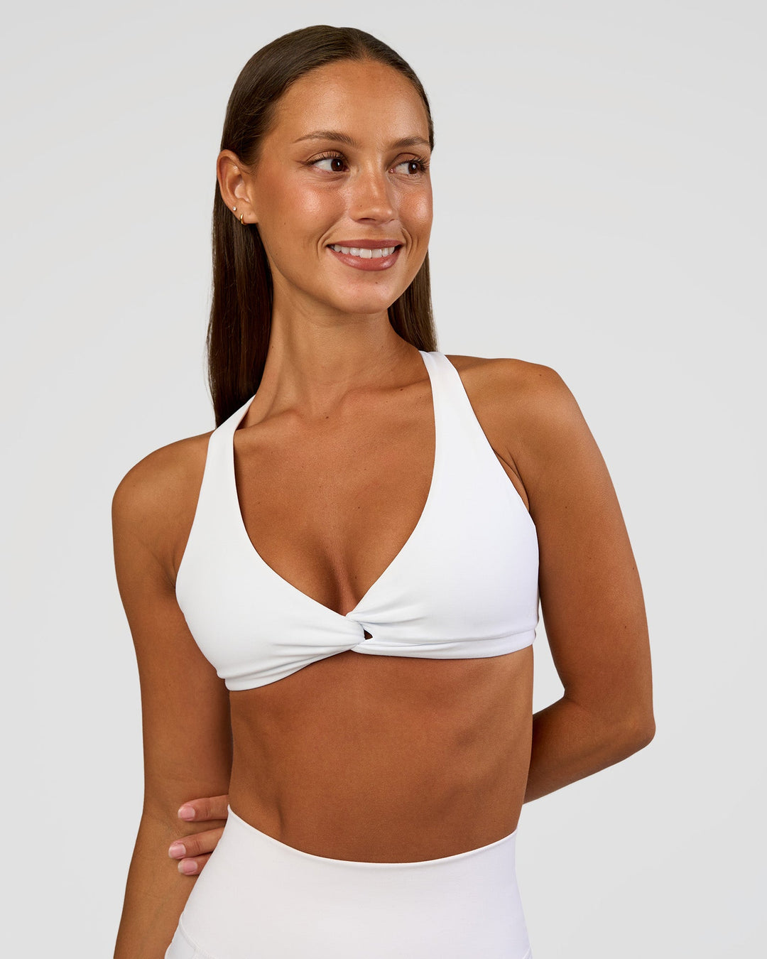 Woman wearing Aspire Twist Sports Bra - White | Model:Brylee | Size:XS