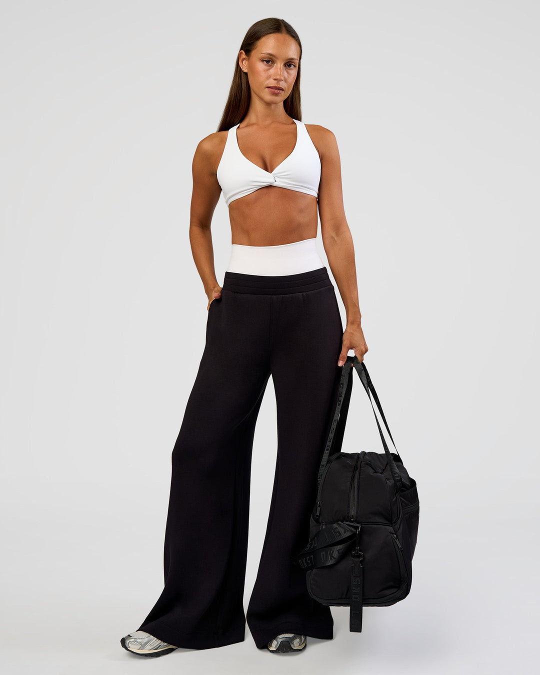 Woman wearing Aspire Twist Sports Bra - White | Model:Brylee | Size:XS