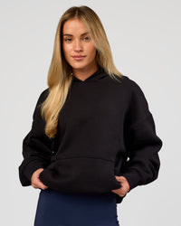 Woman wearing Base Oversized Hoodie - Black | Model:Issy | Size:XS |