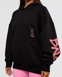 Woman wearing CFT BNE 26 Unisex Oversized Hoodie - Black-Candy Pink | Model:Brylee | Size:XS