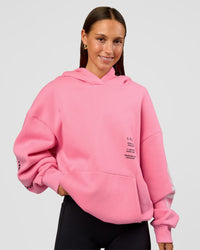 Woman wearing CFT BNE 26 Unisex Oversized Hoodie - Candy Pink-Black | Model:Brylee | Size:XS