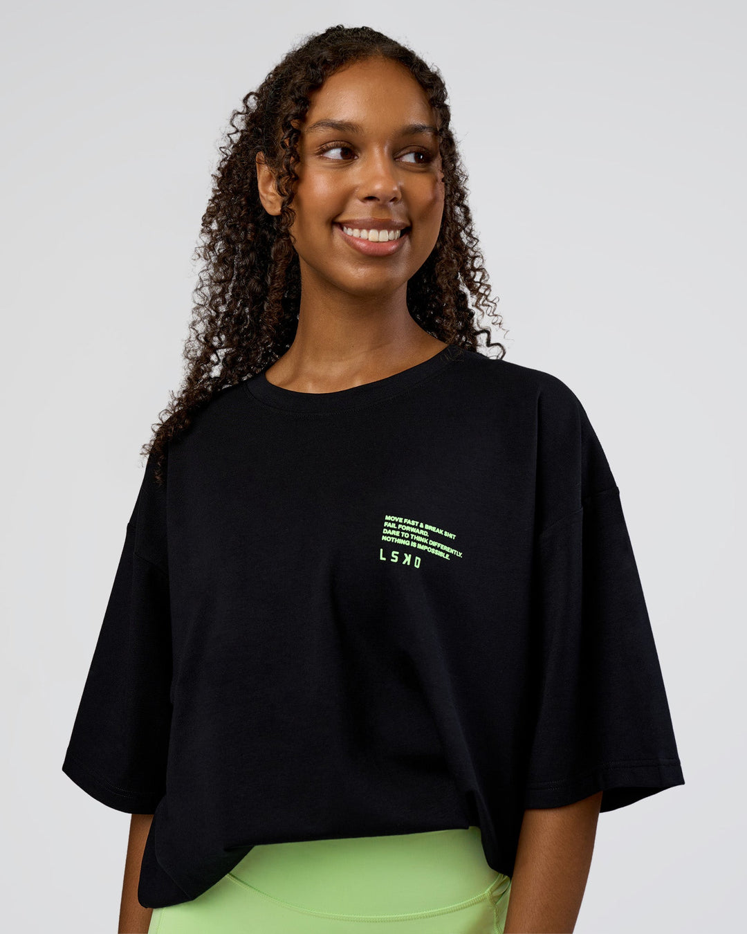 Woman wearing Coffee Run FLXCotton Oversized Tee - Black-Solar Lime | Model:Jordan | Size:XS
