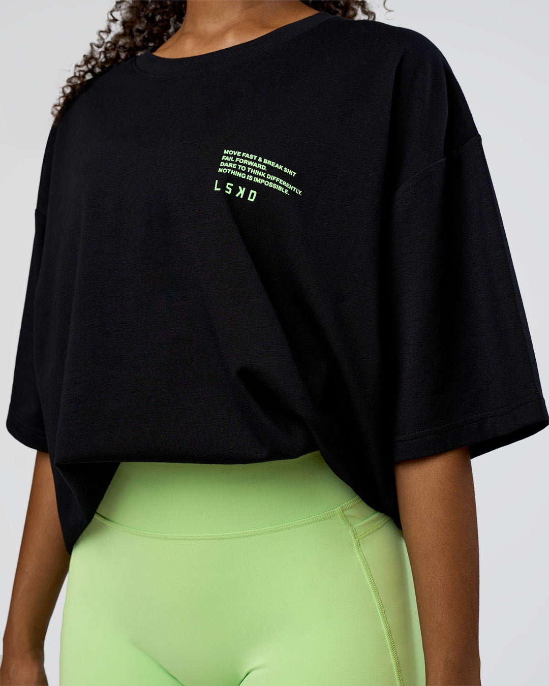 Woman wearing Coffee Run FLXCotton Oversized Tee - Black-Solar Lime | Model:Jordan | Size:XS