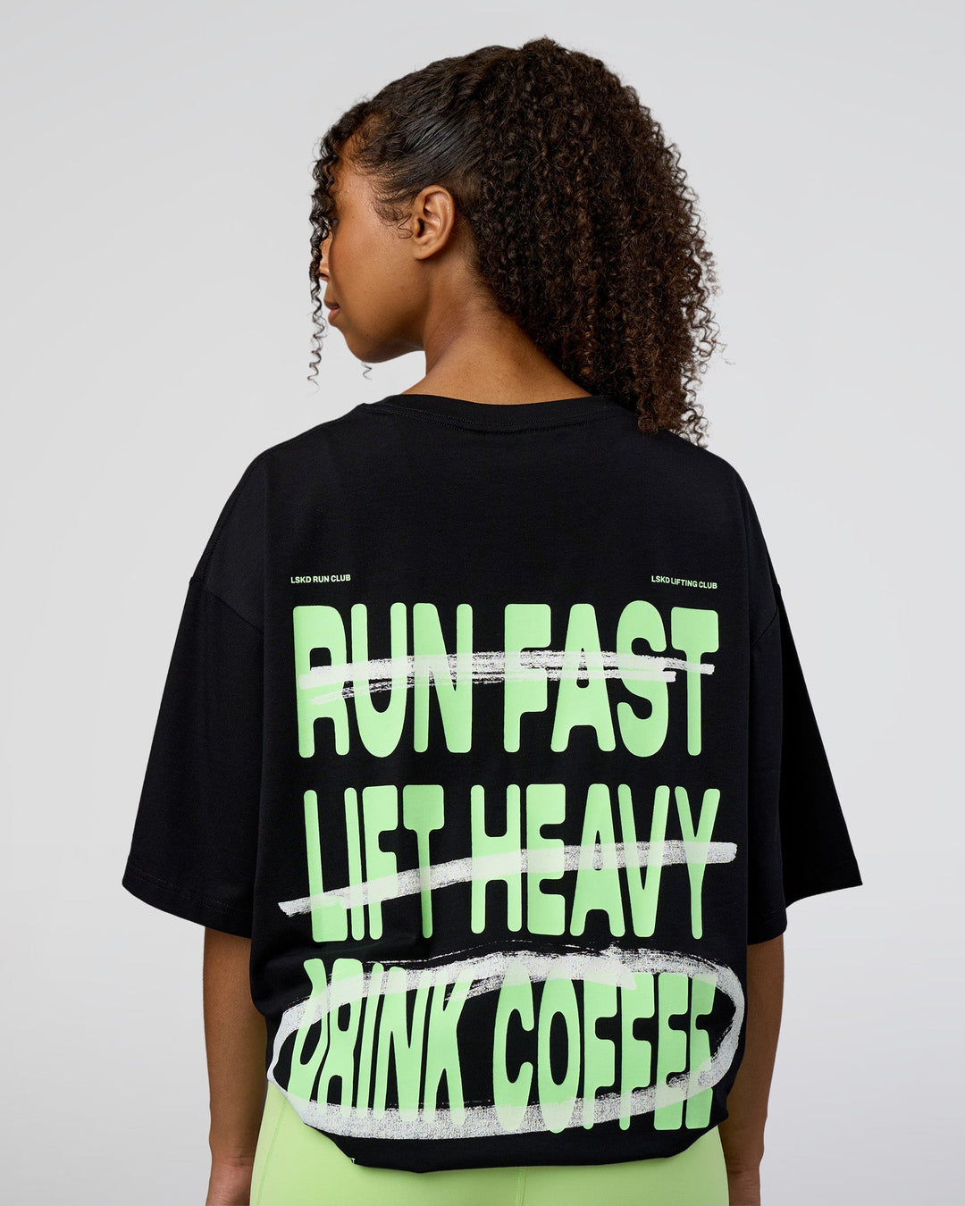 Woman wearing Coffee Run FLXCotton Oversized Tee - Black-Solar Lime | Model:Jordan | Size:XS