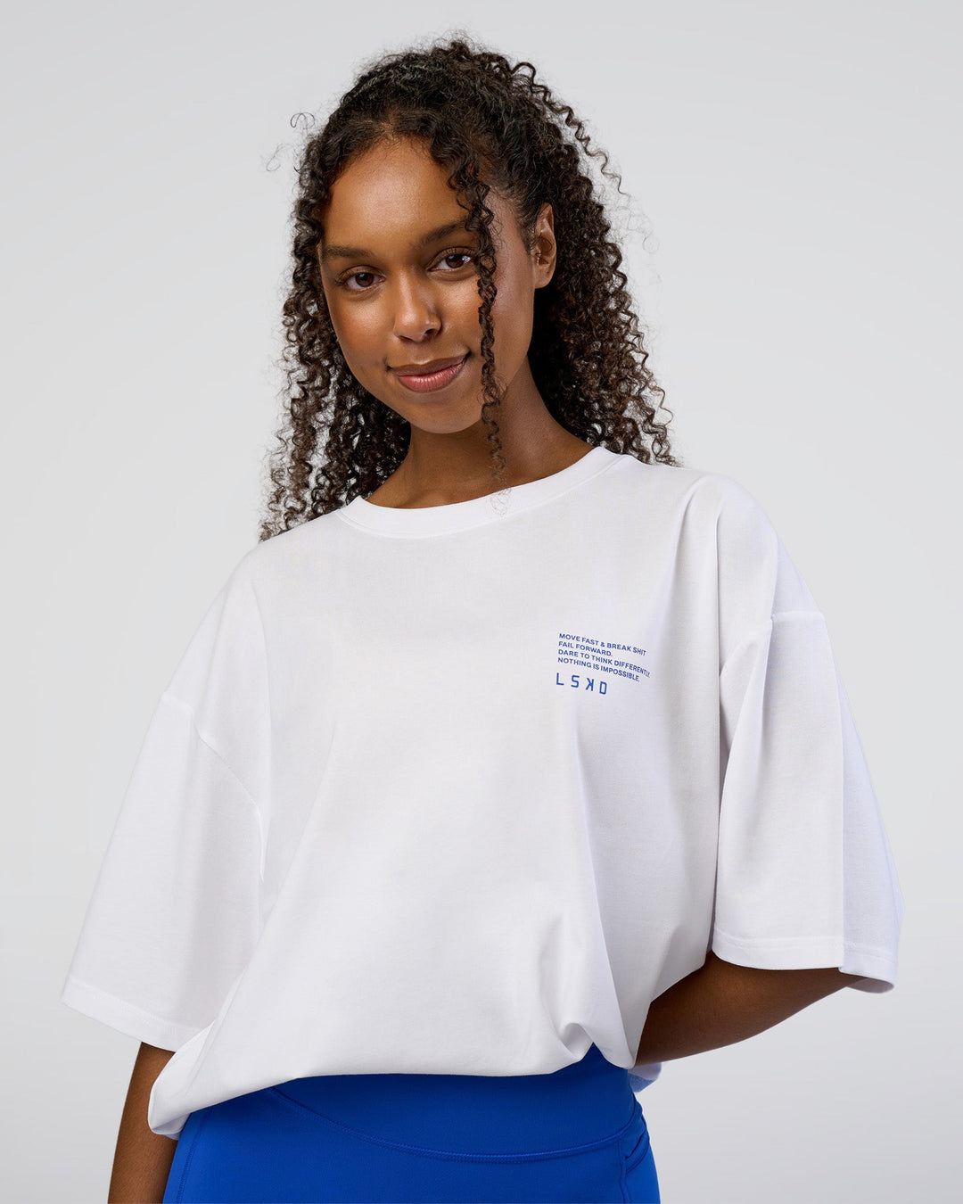 Woman wearing Coffee Run FLXCotton Oversized Tee - White-Electric Indigo | Model:Jordan | Size:L
