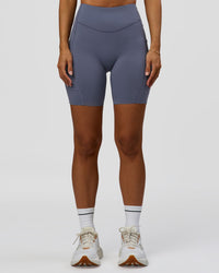Woman wearing Elite Run High-Rise 7" Short Pockets - Night Shadow | Model:Brylee | Size:XS