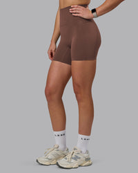 Woman wearing Elixir Ultra High-Rise 6" Short Pockets - Chocolate Martini | Model:Chloe | Size:XS