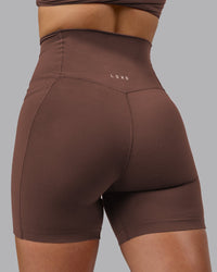 Woman wearing Elixir Ultra High-Rise 6" Short Pockets - Chocolate Martini | Model:Chloe | Size:XS