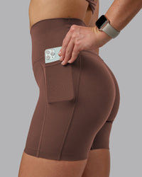 Woman wearing Elixir Ultra High-Rise 6" Short Pockets - Chocolate Martini | Model:Chloe | Size:XS