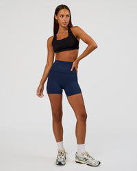 Woman wearing Elixir Ultra High-Rise 4" Short Pockets - Future Navy | Model:Brylee | Size:XS