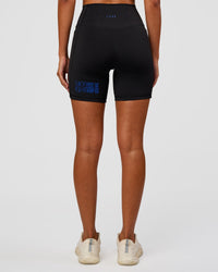 Woman wearing Fusion Hype Graphic Ultra High-Rise 6" Short Pockets - Black-Electric Indigo | Model:Charli | Size:XS