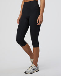 Woman wearing Fusion Ultra High-Rise 3/4 Legging Pockets - Black | Model:Eliza | Size:XS