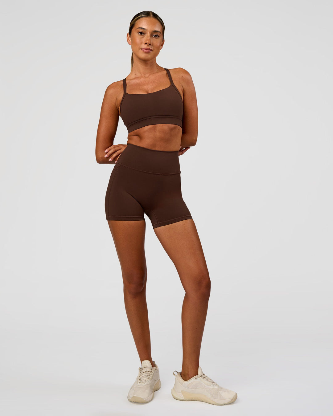 Woman wearing Fusion Ultra High-Rise 4" Short Pockets - Hot Chocolate | Model:Charli | Size:XS
