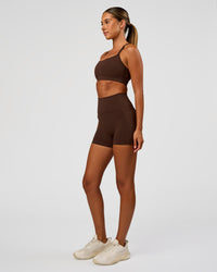 Woman wearing Fusion Ultra High-Rise 4" Short Pockets - Hot Chocolate | Model:Charli | Size:XS