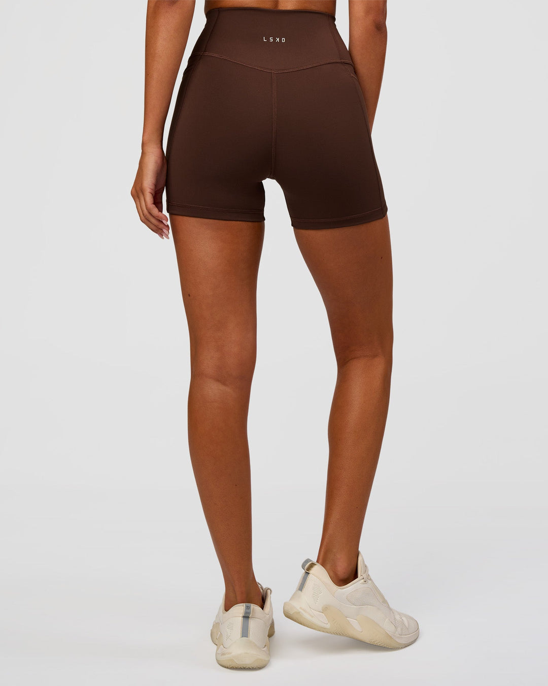 Woman wearing Fusion Ultra High-Rise 4" Short Pockets - Hot Chocolate | Set:true | Angle:back | Model:Charli | Size:XS