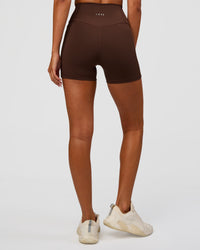 Woman wearing Fusion Ultra High-Rise 4" Short Pockets - Hot Chocolate | Set:true | Angle:back | Model:Charli | Size:XS