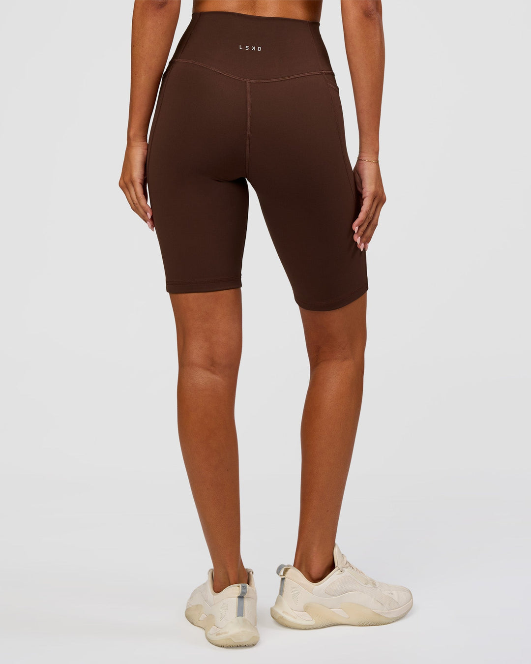 Woman wearing Fusion Ultra High-Rise 9" Short Pockets - Hot Chocolate | Model:Charli | Size:XS