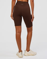 Woman wearing Fusion Ultra High-Rise 9" Short Pockets - Hot Chocolate | Model:Charli | Size:XS
